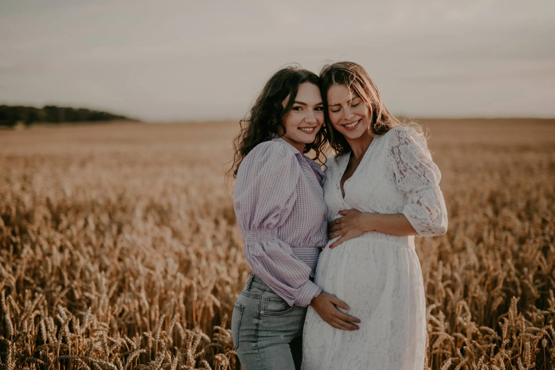 Freundinnen im Feld beim Babybauchshooting