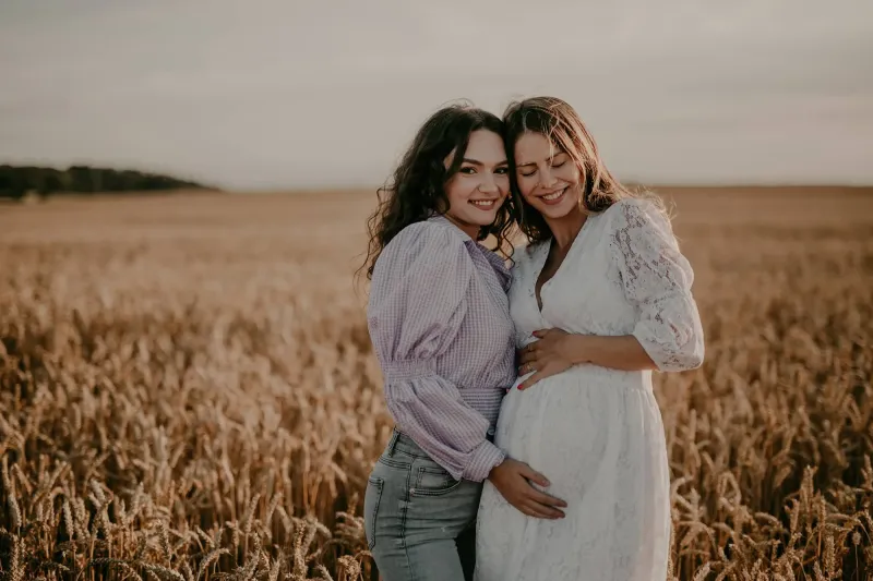 Freundinnen im Feld beim Babybauchshooting