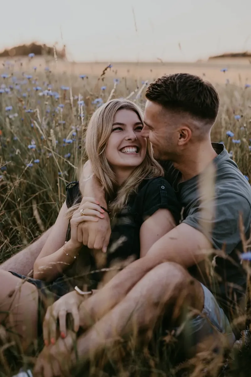 Pärchen sitzt in einer Wildblumenwiese