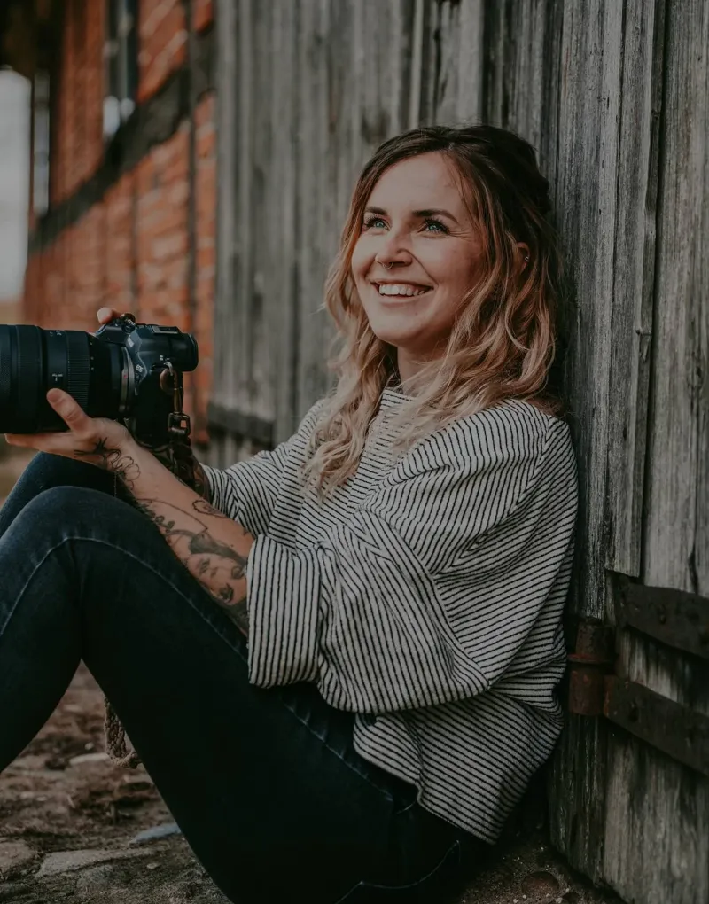 Fotografin mit Kamera vor Holzwand